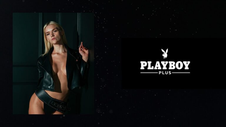 A professional, high-contrast studio portrait of a woman against a minimalist black background with the "Playboy Plus" logo, representing the 2026 digital evolution of the iconic Playmate pictorial.